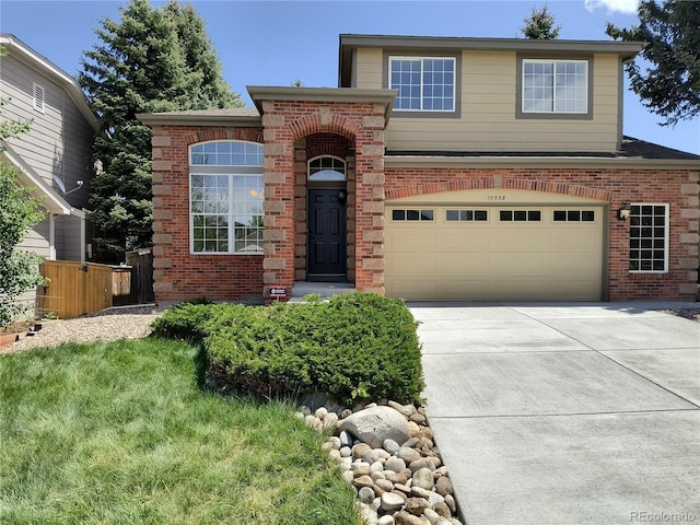traditional-style home featuring brick siding, concrete driveway, an attached garage, and fence