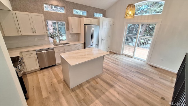 10538 Tiger Chase, Lone Tree, CO 80124 - kitchen featuring appliances with stainless steel finishes, light countertops, healthy amount of natural light, light wood-style floors, and high vaulted ceiling