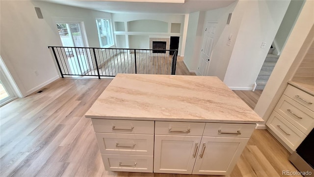 10538 Tiger Chase, Lone Tree, CO 80124 - kitchen with light wood-style floors, white cabinets, built in features, and a kitchen island