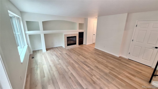 10538 Tiger Chase, Lone Tree, CO 80124 - unfurnished living room featuring light wood finished floors and a fireplace