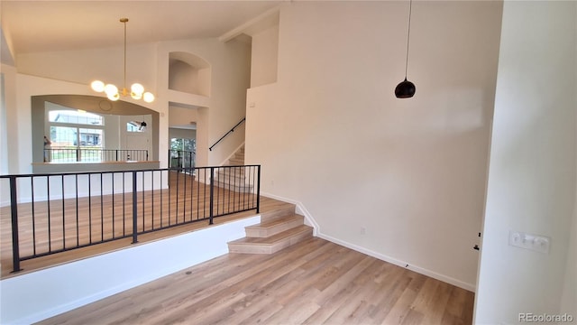 10538 Tiger Chase, Lone Tree, CO 80124 - stairway with wood finished floors, high vaulted ceiling, and a chandelier