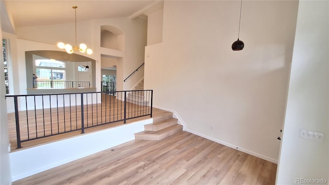 10538 Tiger Chase, Lone Tree, CO 80124 - stairway with wood finished floors, a chandelier, and high vaulted ceiling