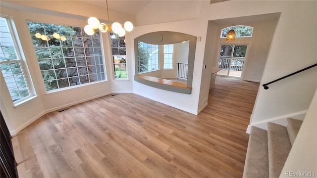 10538 Tiger Chase, Lone Tree, CO 80124 - unfurnished dining area with wood finished floors, plenty of natural light, stairs, and vaulted ceiling