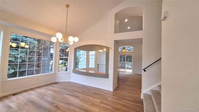 10538 Tiger Chase, Lone Tree, CO 80124 - unfurnished dining area with wood finished floors, stairway, a chandelier, high vaulted ceiling, and arched walkways