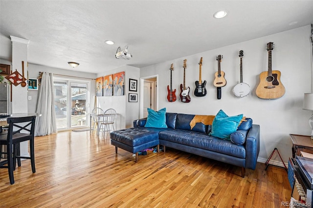 living room with recessed lighting, baseboards, and wood finished floors