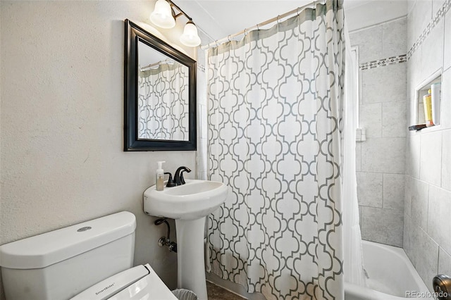 bathroom featuring shower / bathtub combination with curtain and toilet