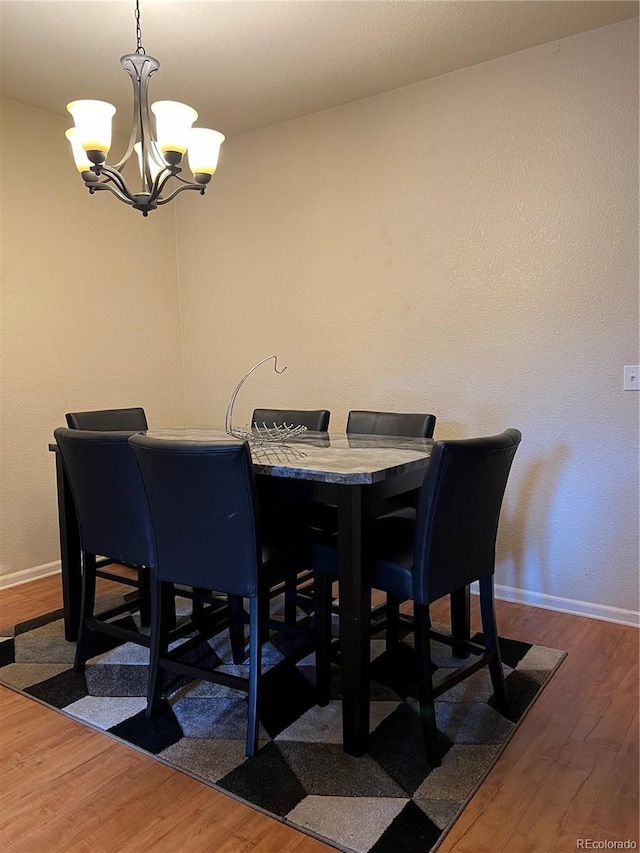 14201 E 1st Dr Unit 104, Aurora, CO 80011 - dining area featuring baseboards, a notable chandelier, and wood finished floors