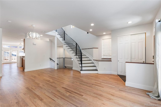 unfurnished living room featuring light hardwood / wood-style flooring and a chandelier