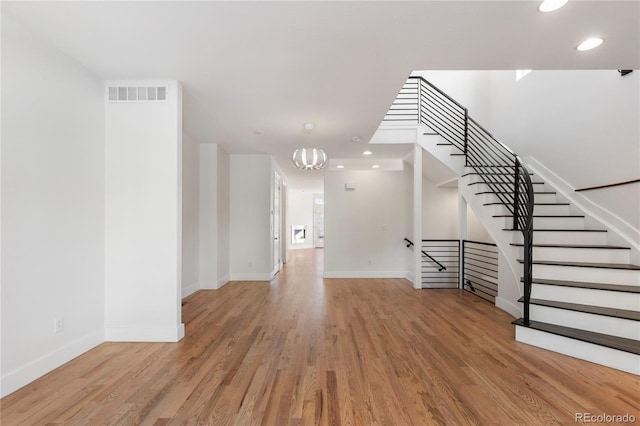 interior space featuring an inviting chandelier and light wood-type flooring