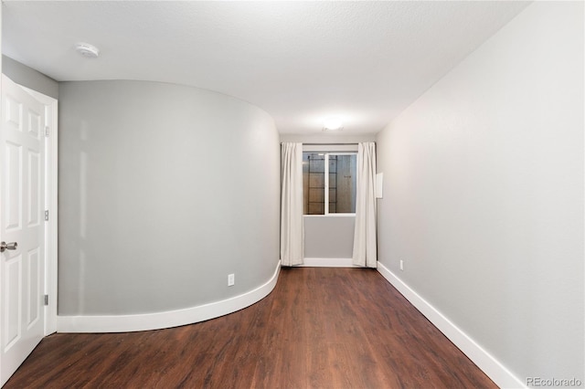 unfurnished room with dark wood-type flooring and a textured ceiling