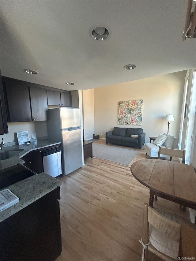 kitchen with appliances with stainless steel finishes, light wood-type flooring, and a sink