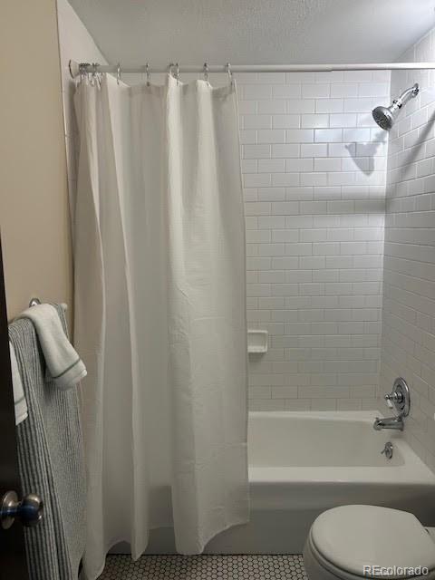 bathroom with toilet, shower / bath combination with curtain, and tile patterned floors