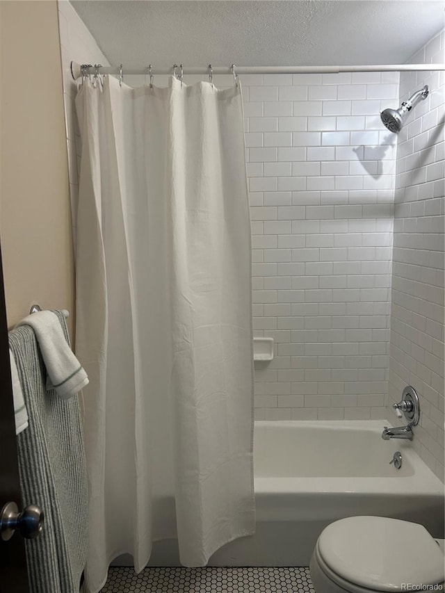 bathroom with shower / bath combination with curtain, tile patterned flooring, a textured ceiling, and toilet