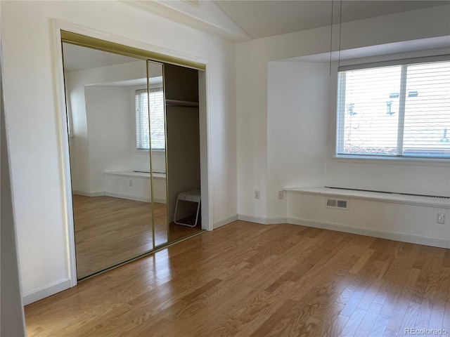 unfurnished bedroom with visible vents, baseboards, and light wood-style floors