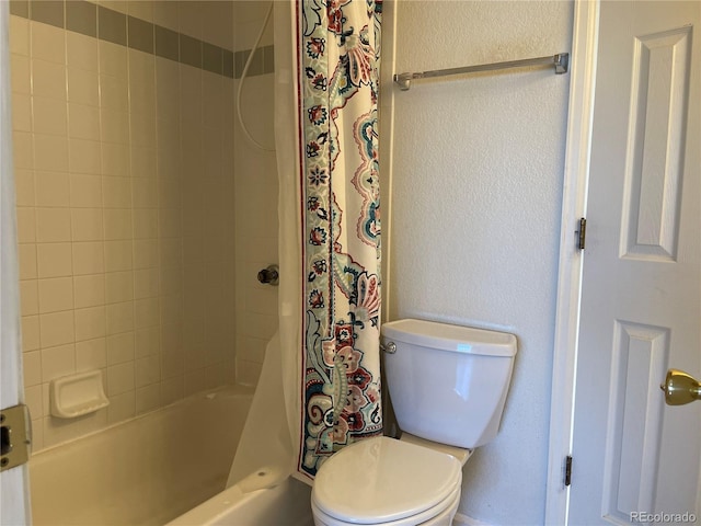 full bath with toilet, shower / bath combo, and a textured wall