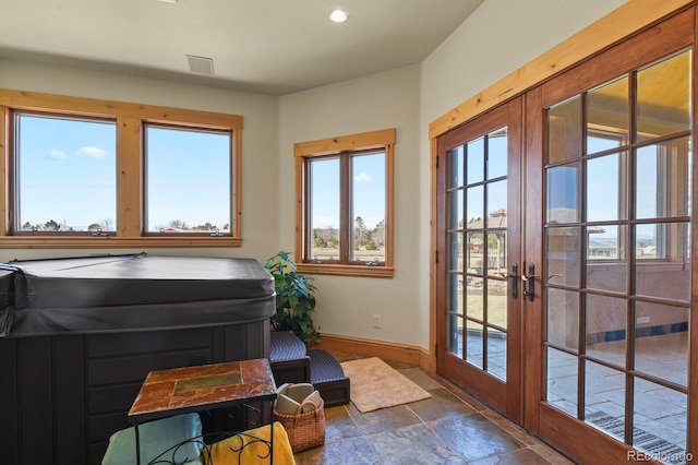 doorway to outside with recessed lighting, baseboards, stone tile flooring, and french doors