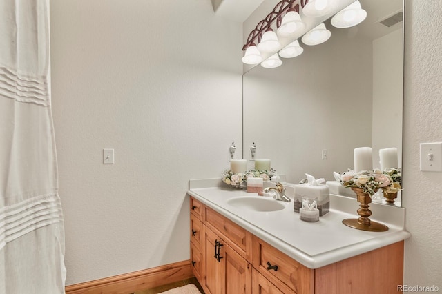 bathroom featuring visible vents, vanity, and baseboards