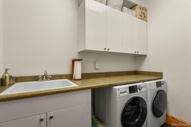 laundry room featuring cabinet space, a sink, and separate washer and dryer