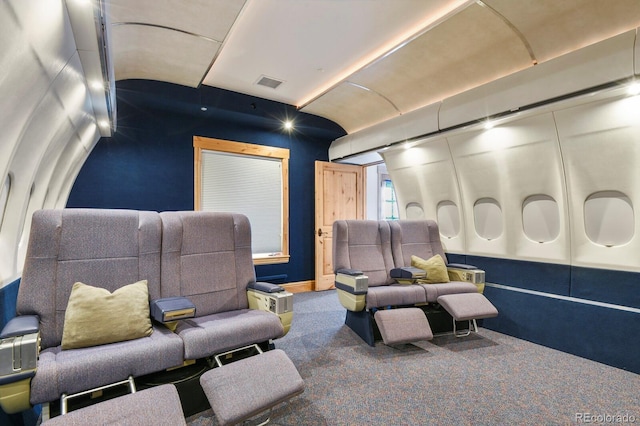 cinema room featuring carpet, visible vents, and lofted ceiling