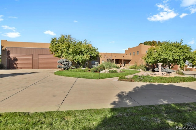 adobe home with driveway, an attached garage, and stucco siding