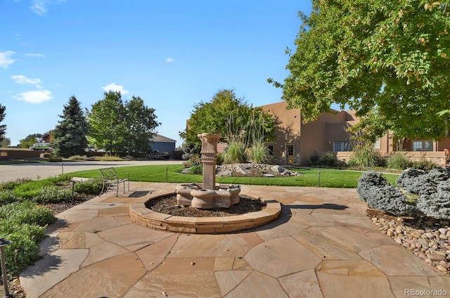 view of property's community featuring a yard and a patio