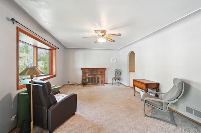 6050 Marshall Ct, Arvada, CO 80003 - carpeted living room with ceiling fan, baseboards, arched walkways, and a brick fireplace