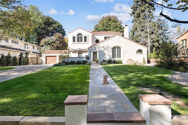 mediterranean / spanish-style house featuring stucco siding, a chimney, fence, a front lawn, and driveway