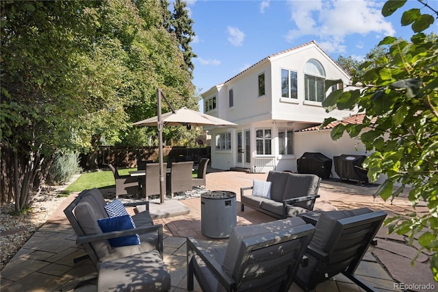 view of patio / terrace with an outdoor living space with a fire pit, a grill, a fenced backyard, and outdoor dining space