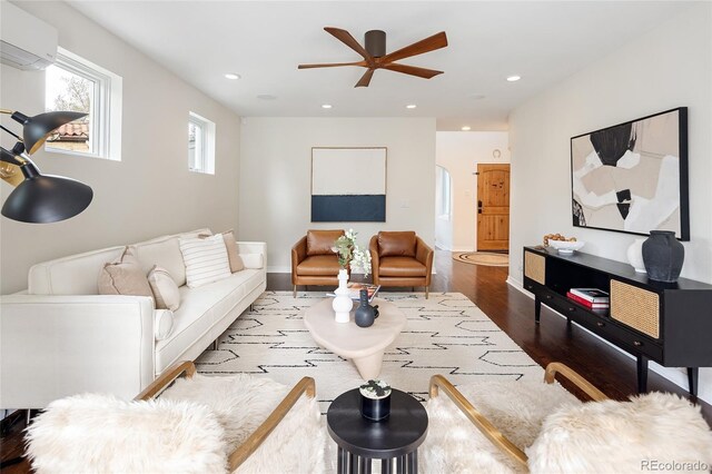 living room with a ceiling fan, wood finished floors, recessed lighting, and an AC wall unit