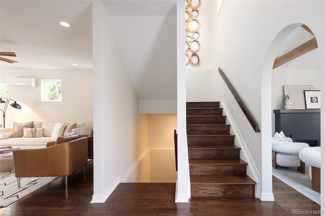 stairway featuring a wall mounted air conditioner, wood finished floors, recessed lighting, ceiling fan, and baseboards