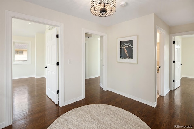 corridor with baseboards and dark wood finished floors