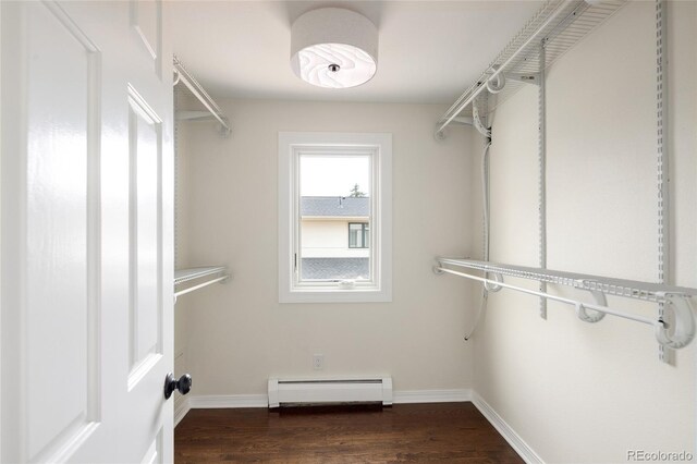walk in closet with baseboard heating and wood finished floors