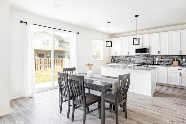 dining space with sink and light hardwood / wood-style flooring