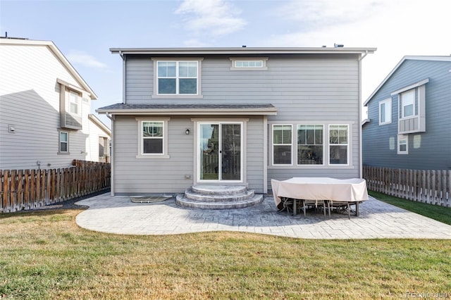 back of house with a lawn and a patio