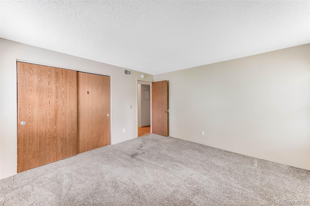 4896 S Dudley St Unit 4-7, Littleton, CO 80123 - unfurnished bedroom with carpet floors, a closet, and a textured ceiling