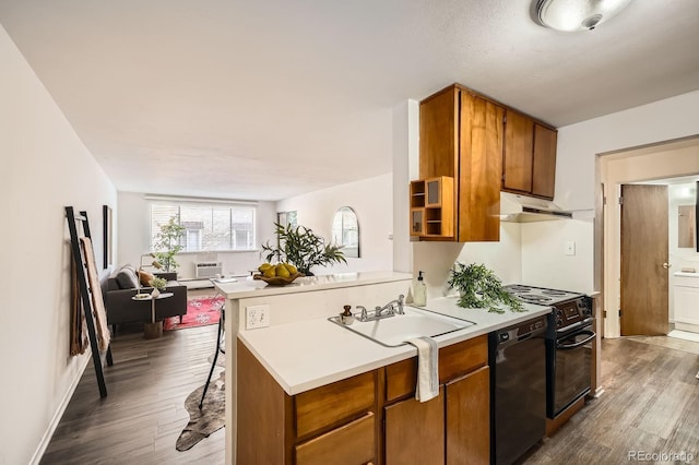 kitchen featuring black appliances, light countertops, dark wood-type flooring, under cabinet range hood, and brown cabinets