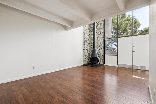 384 S Ironton St Unit 413, Aurora, CO 80012 - unfurnished living room with beam ceiling, wood finished floors, a wood stove, and baseboards