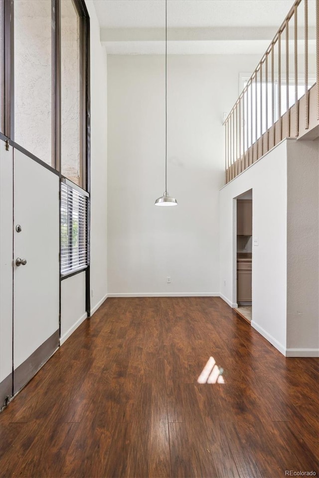 384 S Ironton St Unit 413, Aurora, CO 80012 - unfurnished room featuring wood finished floors, baseboards, and a towering ceiling