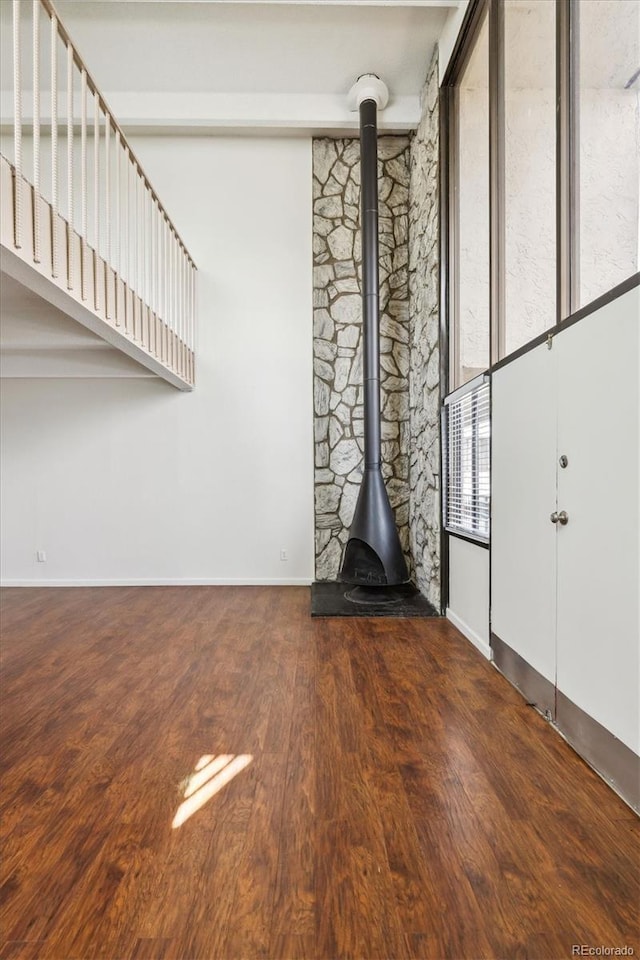 384 S Ironton St Unit 413, Aurora, CO 80012 - unfurnished living room with baseboards, wood finished floors, and a wood stove