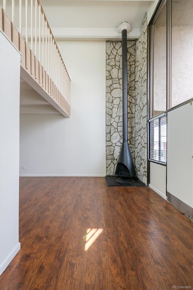 384 S Ironton St Unit 413, Aurora, CO 80012 - unfurnished living room featuring wood finished floors, baseboards, and a wood stove