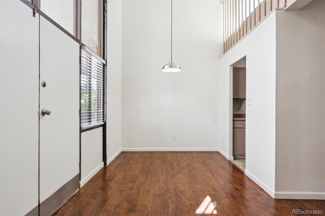 384 S Ironton St Unit 413, Aurora, CO 80012 - unfurnished dining area with a high ceiling, wood finished floors, and baseboards
