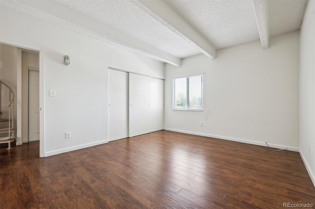 384 S Ironton St Unit 413, Aurora, CO 80012 - unfurnished bedroom featuring beam ceiling, wood finished floors, a closet, a textured ceiling, and baseboards
