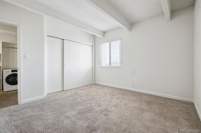 384 S Ironton St Unit 413, Aurora, CO 80012 - unfurnished bedroom with washer / clothes dryer, carpet, beamed ceiling, a closet, and a textured ceiling
