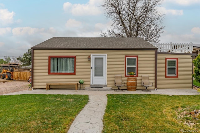 5910 Glencoe St, Commerce City, CO 80022 - bungalow with a front yard, a patio area, roof with shingles, and fence