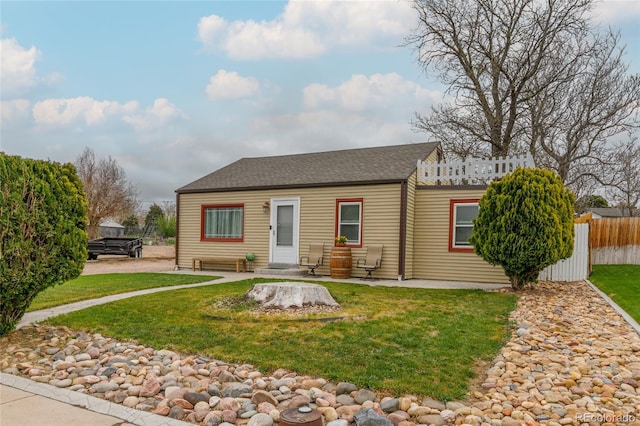 5910 Glencoe St, Commerce City, CO 80022 - bungalow with a shingled roof, fence, and a front yard