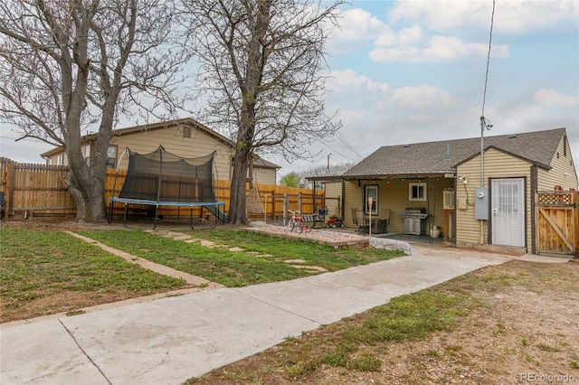 5910 Glencoe St, Commerce City, CO 80022 - view of yard with a trampoline, a patio, a gate, and a fenced backyard