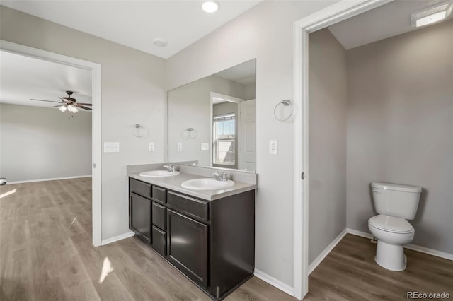 bathroom with vanity, hardwood / wood-style flooring, toilet, and ceiling fan