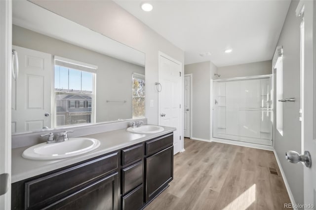 bathroom with vanity, an enclosed shower, and wood-type flooring