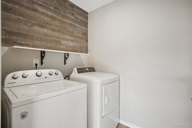 washroom featuring separate washer and dryer and wooden walls