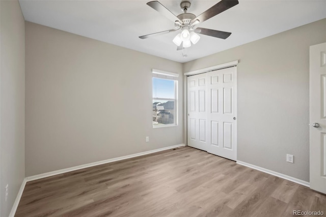 unfurnished bedroom with a closet, light hardwood / wood-style floors, and ceiling fan